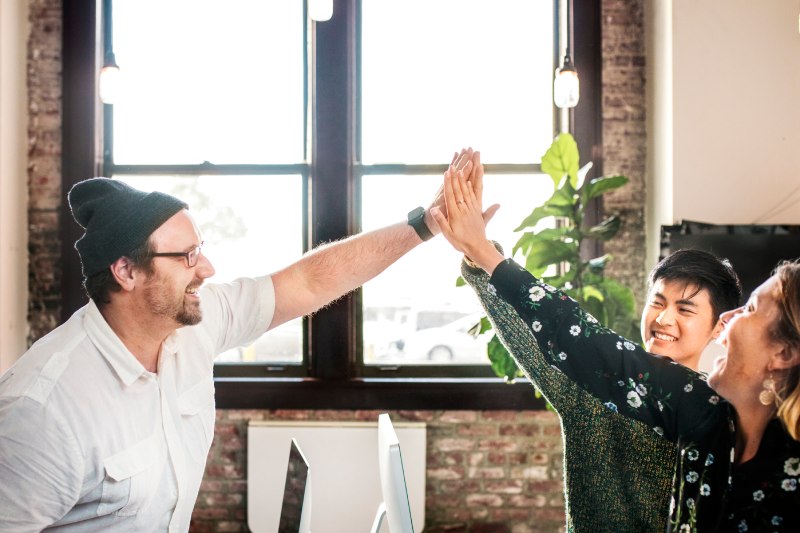3 partenaires au sein d'un réseau affichent des sourires radieux alors qu'ils se tapent la main les uns avec les autres. L’image illustre l'esprit d'équipe, la camaraderie et la confiance qui sont au cœur d'une collaboration efficace et gratifiante. Ils font progresser leur réseau vers de nouveaux sommets !