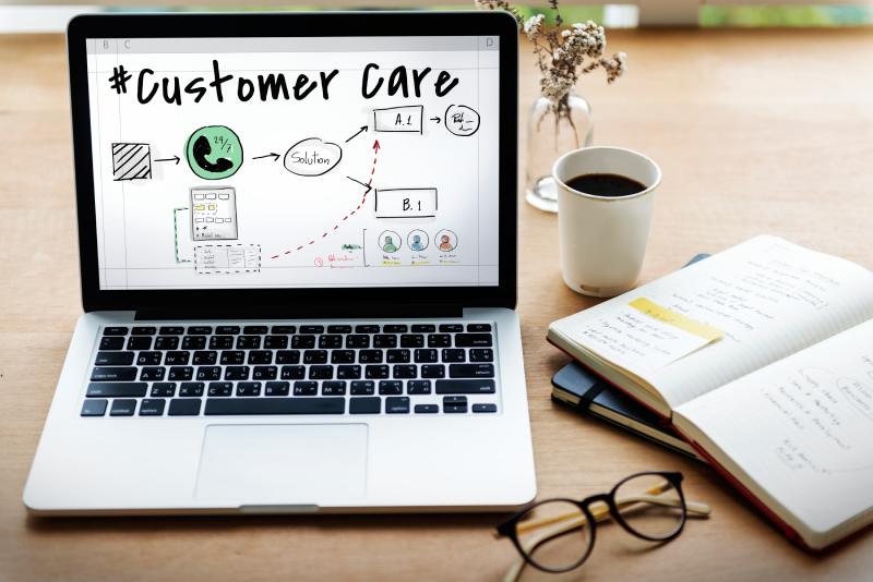 Un ordi sur une table. Un cadre professionnel où la technologie est utilisée pour optimiser la relation client et la connectivité au sein d'un réseau hybride.