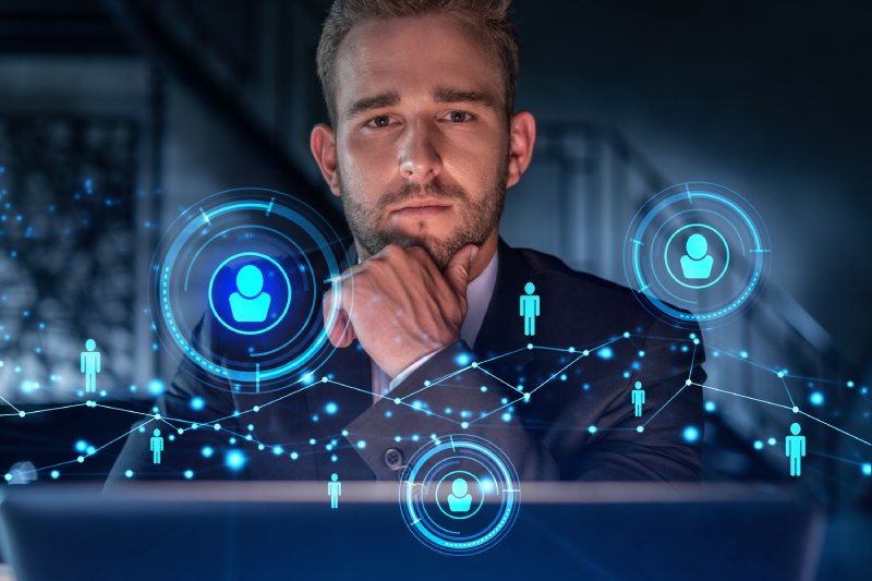 Un homme sérieux se plonge dans la réflexion face aux défis posés par les réseaux hybrides. Devant lui, des hologrammes représentent visuellement les complexités et les possibilités de ces réseaux innovants. L'atmosphère est chargée de concentration et d'engagement, soulignant l'importance stratégique de cette réflexion.