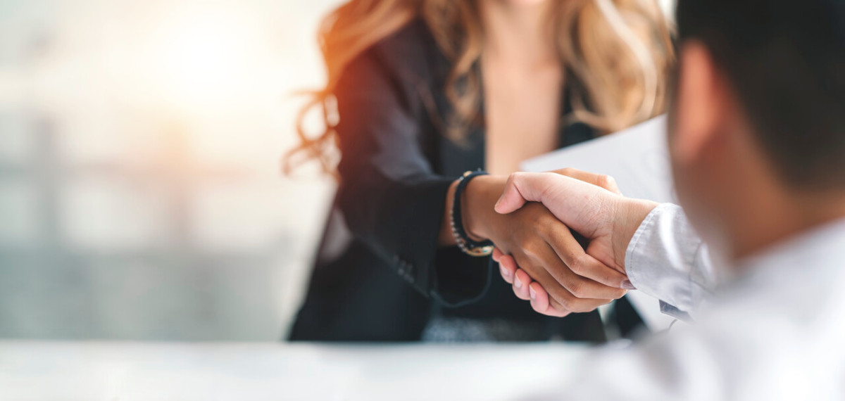 Une commerciale a finalisé une transaction avec assurance. Elle tient un dossier sous son bras, symbole de professionnalisme et de préparation.