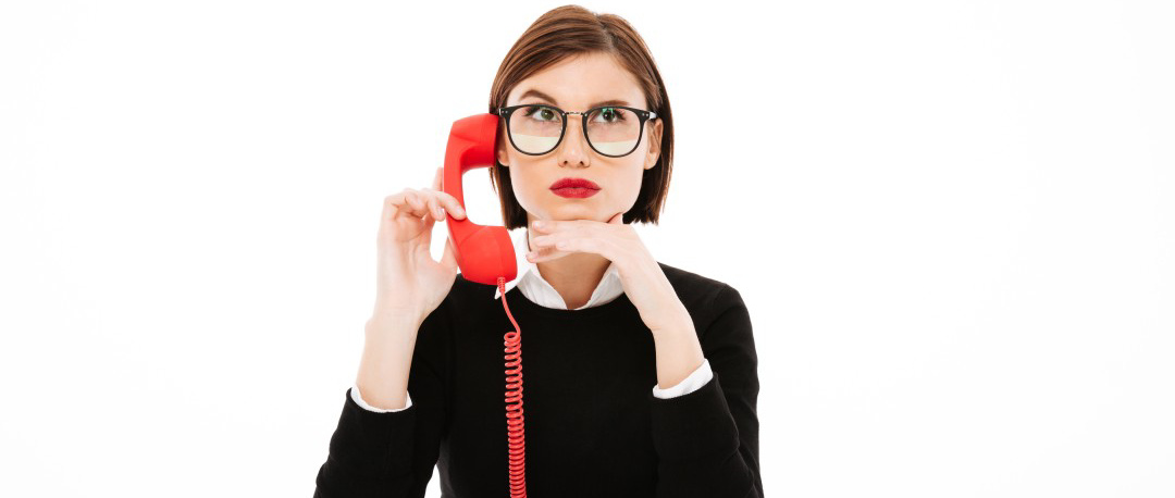Une femme sérieuse et concentrée en train de faire de la prospection téléphonique. Elle est assise à un bureau, portant une lunette et écoutant attentivement au téléphone, démontrant son professionnalisme. Son visage reflète le sérieux de son travail. Cette scène capte l'essence d'une communicatrice engagée et dévouée à ses activités professionnelles.